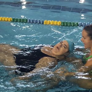 donna con disabilità in piscina con istruttrice