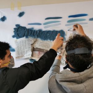 due ragazzi fanno un murales