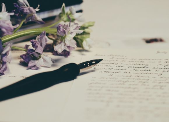 dei fiori e una penna su un foglio